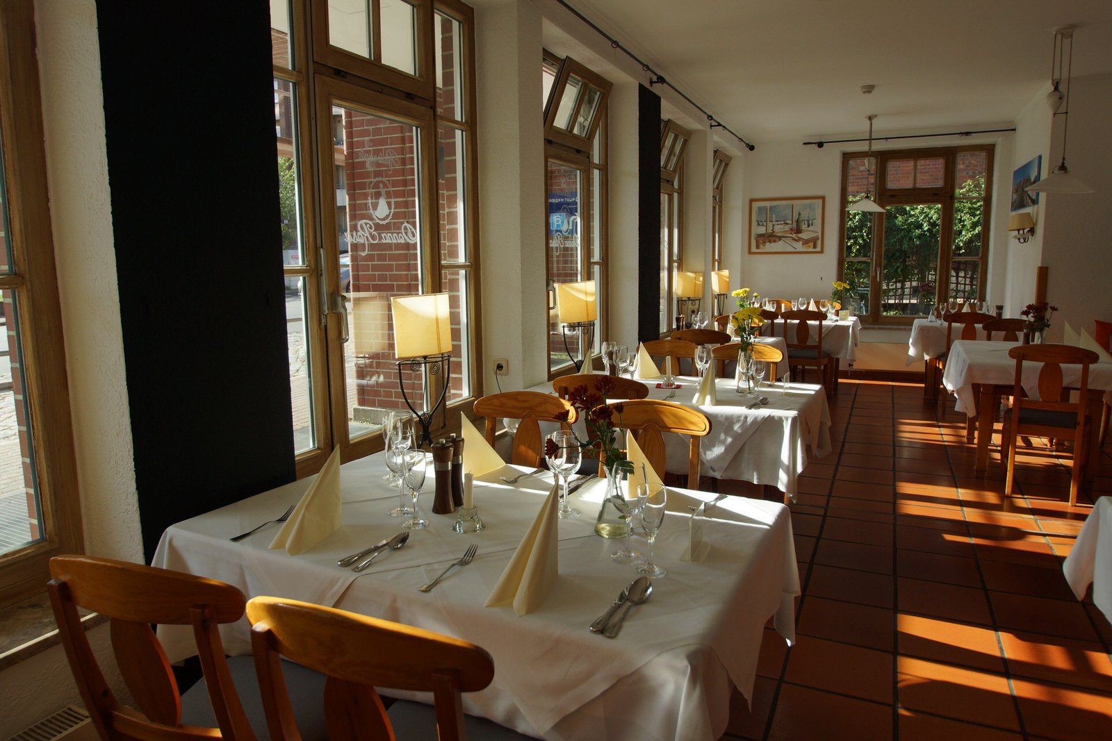Heller Gastraum des Ristorante Donna Rosa mit gedeckten Tischen am Fenster